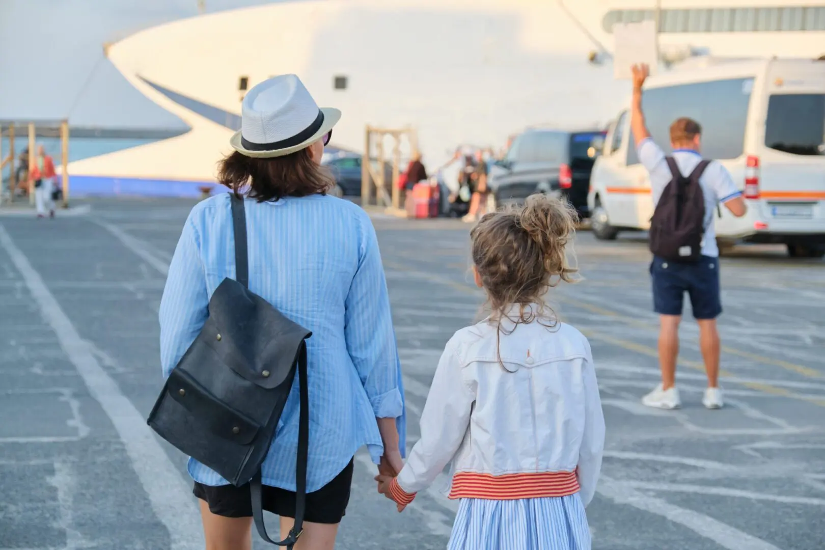 Mother and daughter holding hands boarding ferry