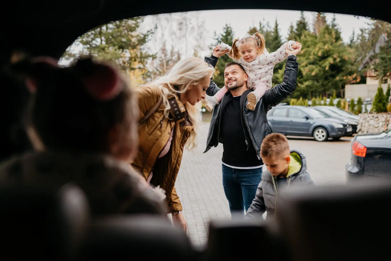 Family loading car with joyful children
