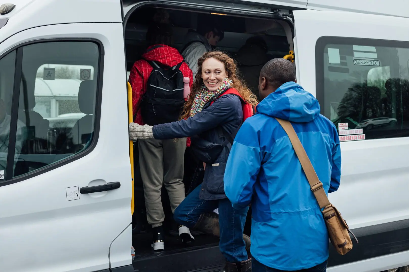 Smiling woman boarding white shuttle van