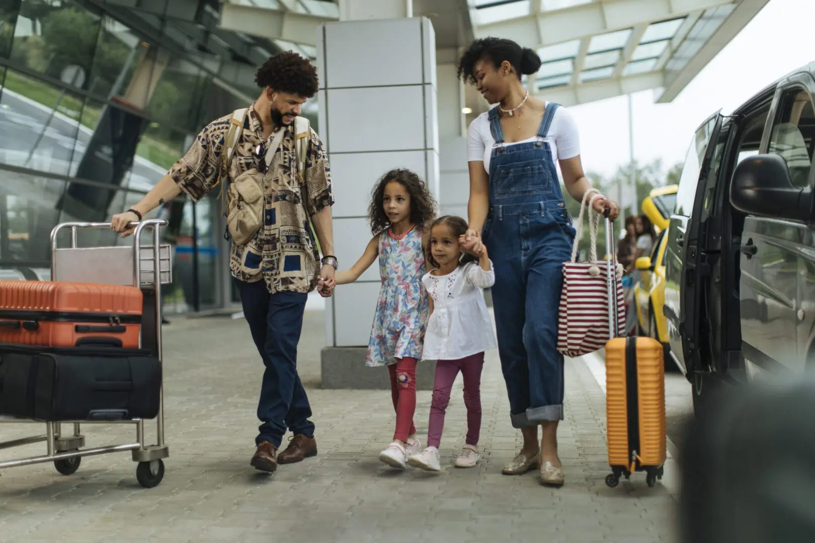Family of four with luggage at airport