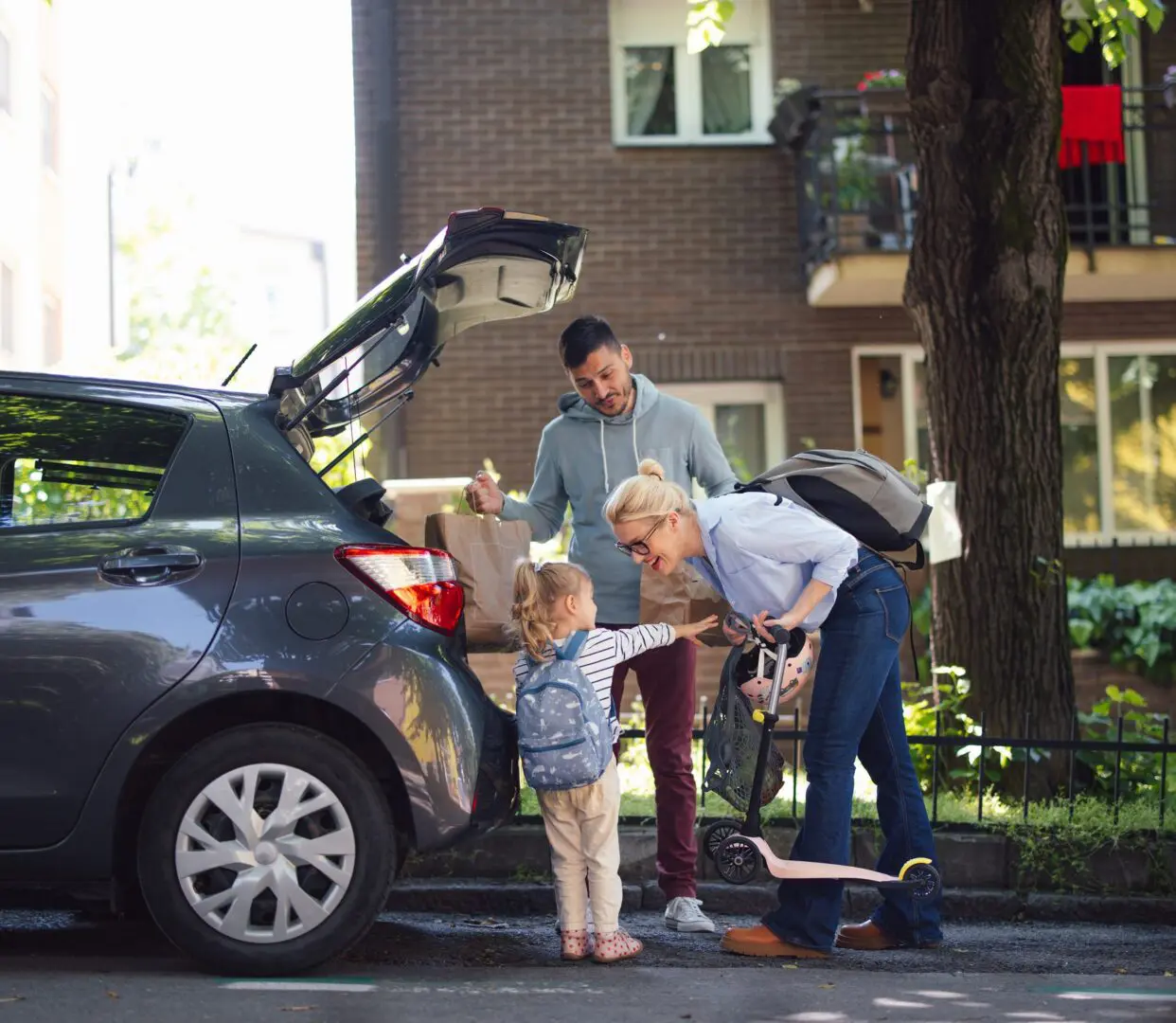 Parents helping young child out of car