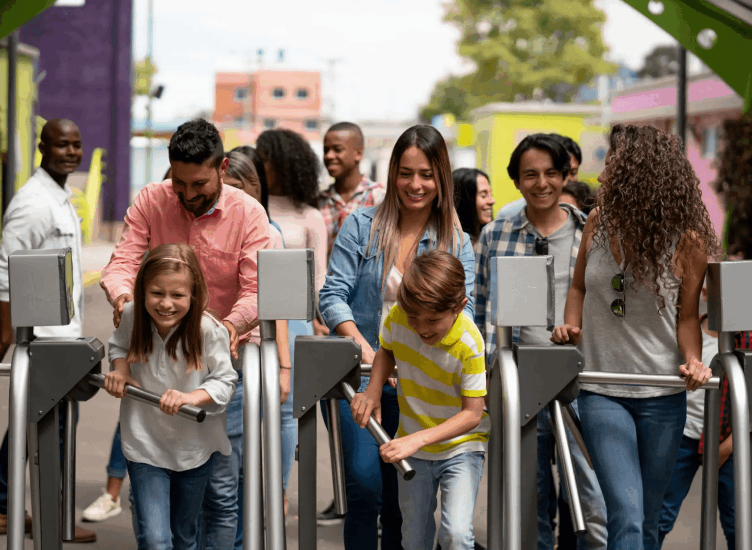 Families and children entering amusement park turnstiles
