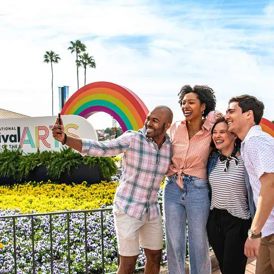 Friends taking selfie at colorful rainbow festival